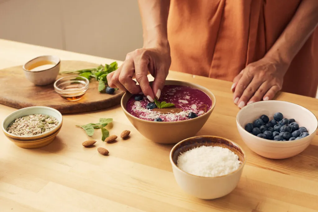 Come preparare un'acai bowl in casa con mirtilli, cocco, burro di arachidi e topping salutari.
