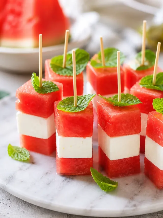 Spiedini di anguria, feta light e menta su piatto chiaro