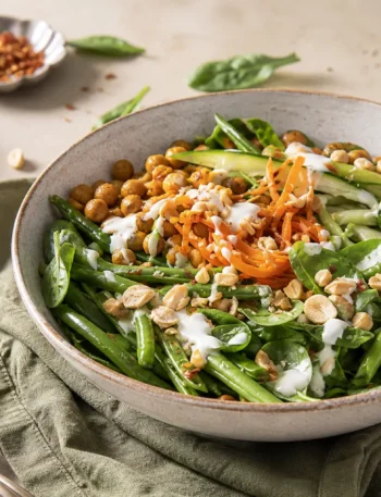 Insalata di ceci con yogurt e curry, spinaci, fagiolini, carote e arachidi