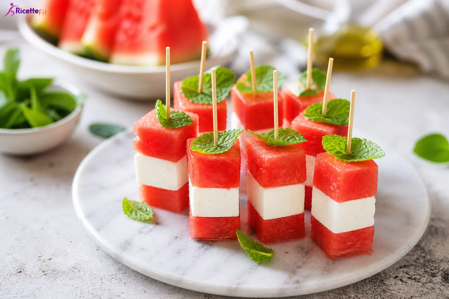 Spiedini di anguria, feta light e menta su piatto chiaro