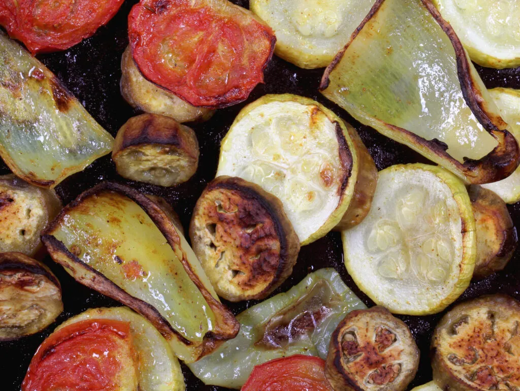 Primo piano di verdure al forno con i bordi dorati
