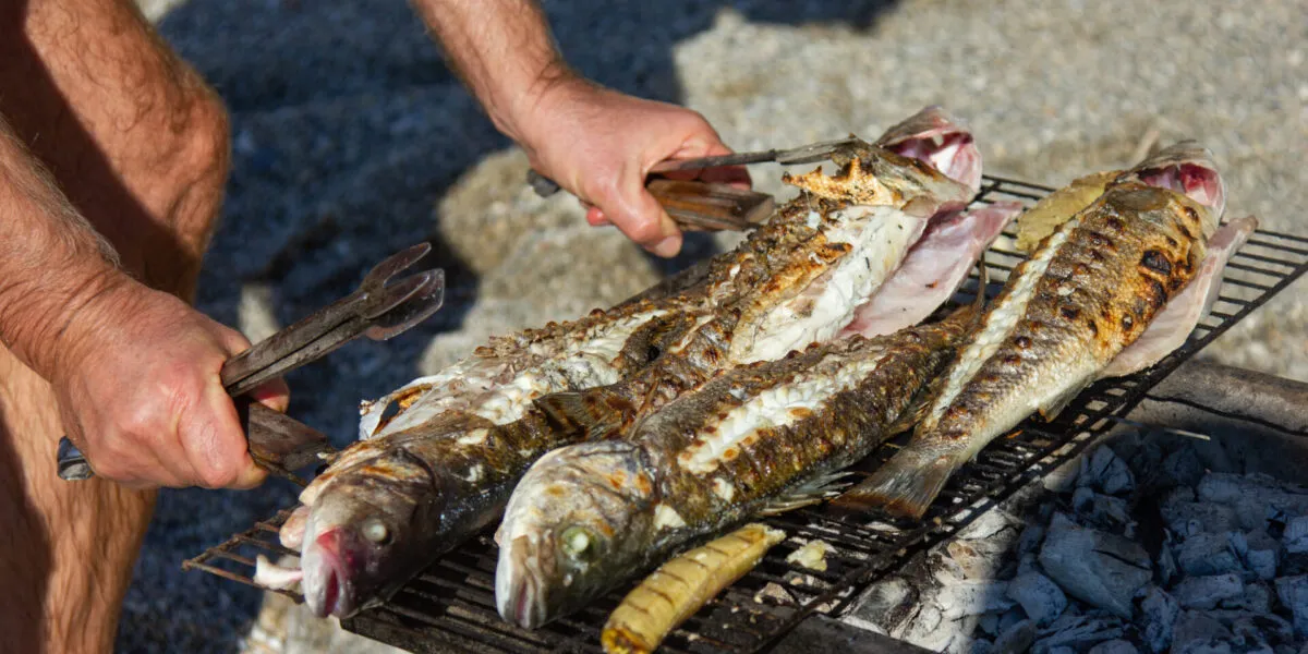 Pesci interi grigliati su una griglia a carbone