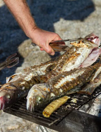 Pesci interi grigliati su una griglia a carbone