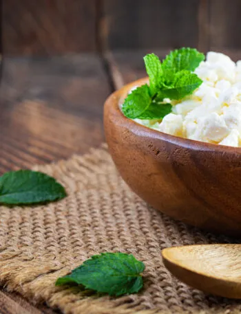 Fiocchi di latte in una ciotola di legno con foglie di menta fresca
