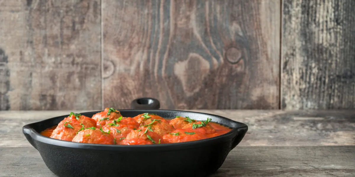 Polpette fit al sugo di pomodoro con prezzemolo in padella di ghisa nera