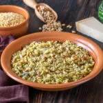 Piatto di orzo perlato condito con erbe aromatiche, pinoli tostati e formaggio grattugiato.