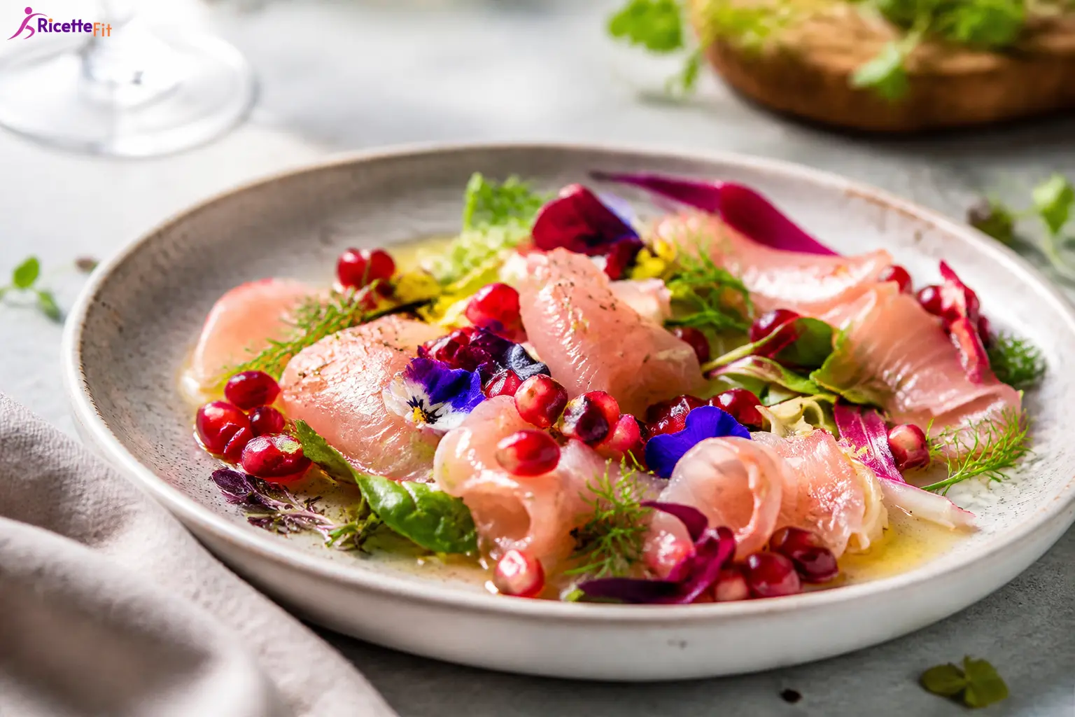 Carpaccio di ricciola con melograno, lime, zenzero e misticanza