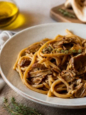 Pasta integrale ai funghi porcini in piatto fondo con timo fresco