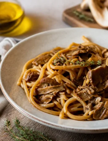 Pasta integrale ai funghi porcini in piatto fondo con timo fresco
