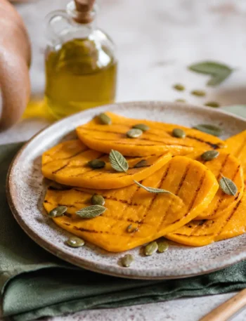 Zucca grigliata con salvia e semi di zucca nel piatto