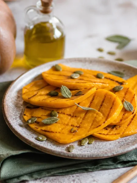 Zucca grigliata con salvia e semi di zucca nel piatto