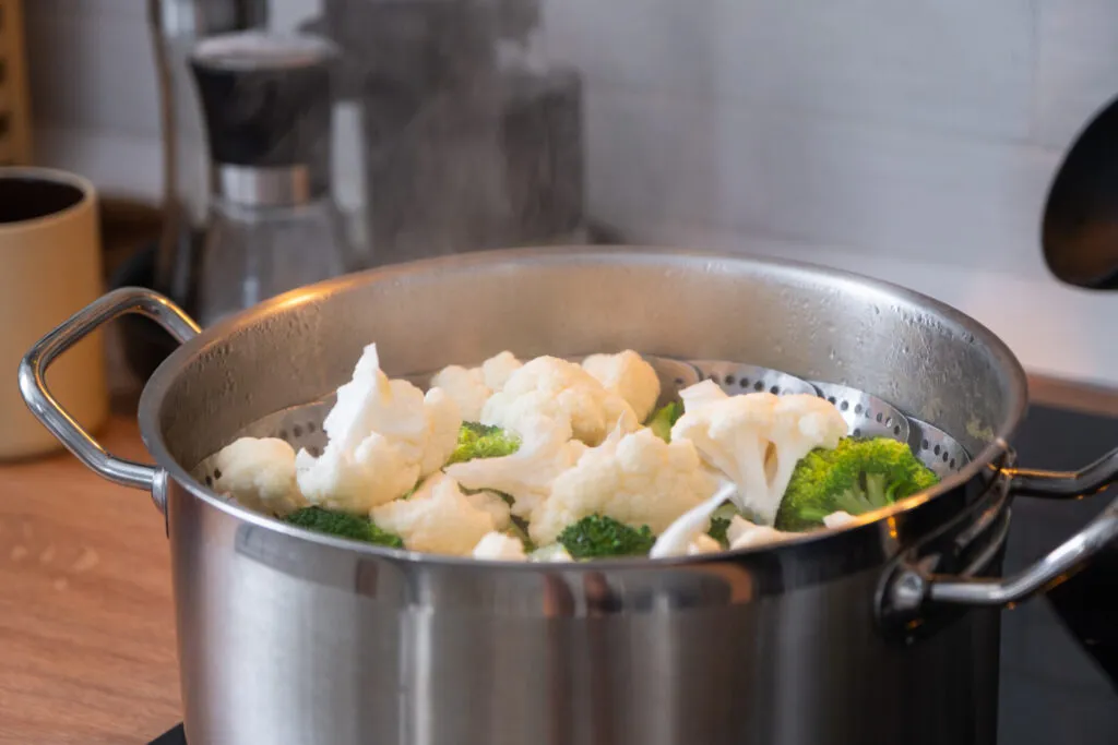 Cavolfiore e broccoli nel cestello a vapore in pentola scoperta