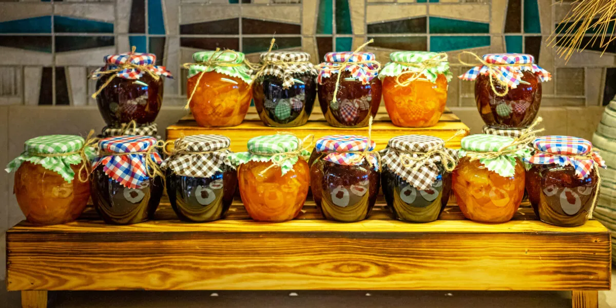 Vasetti di confetture di frutta diversa su un espositore di legno