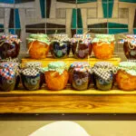Vasetti di confetture di frutta diversa su un espositore di legno
