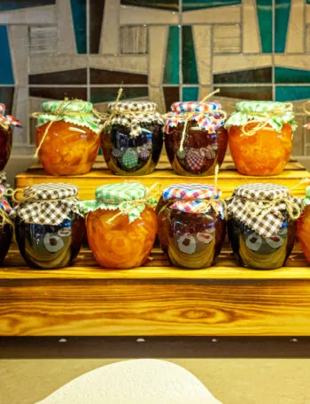 Vasetti di confetture di frutta diversa su un espositore di legno
