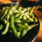 Baccelli di edamame verdi in una ciotola scura