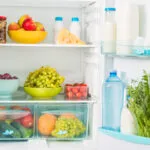 Interno di un frigorifero con frutta, latticini e verdure sui ripiani