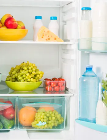 Interno di un frigorifero con frutta, latticini e verdure sui ripiani