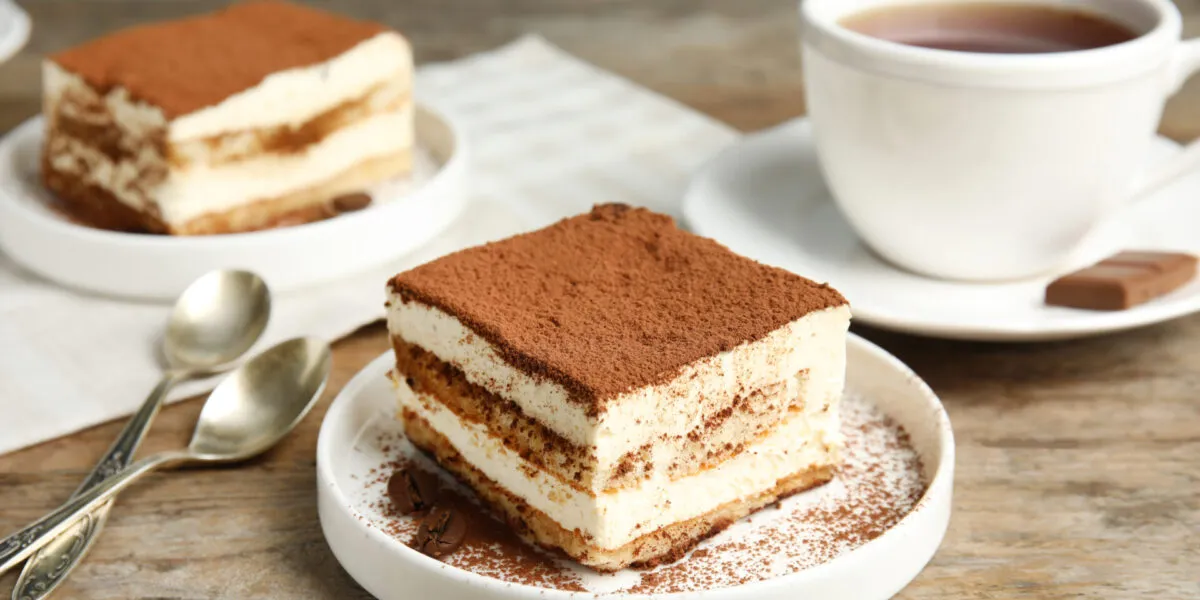 Porzione di tiramisù con strati di crema e savoiardi e cacao amaro