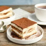 Porzione di tiramisù con strati di crema e savoiardi e cacao amaro