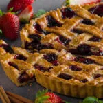 Crostata ai frutti rossi con grata di frolla e una fetta tagliata