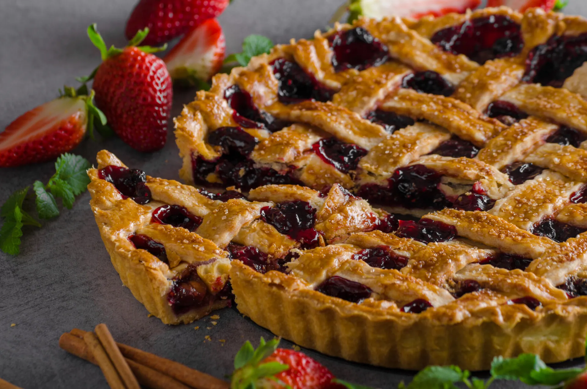 Crostata ai frutti rossi con grata di frolla e una fetta tagliata