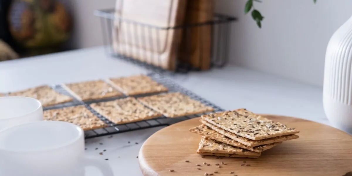 Cracker ai semi impilati su un tagliere di legno con gratella