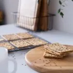 Cracker ai semi impilati su un tagliere di legno con gratella