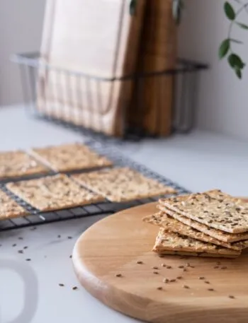 Cracker ai semi impilati su un tagliere di legno con gratella