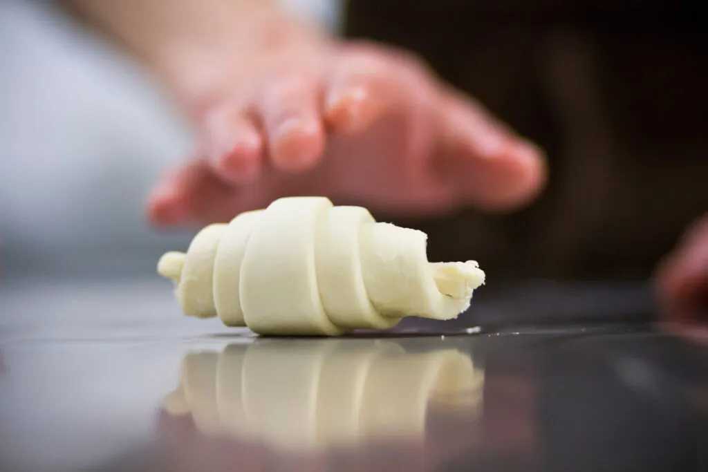 Cornetto crudo appena arrotolato con la punta rivolta verso il basso
