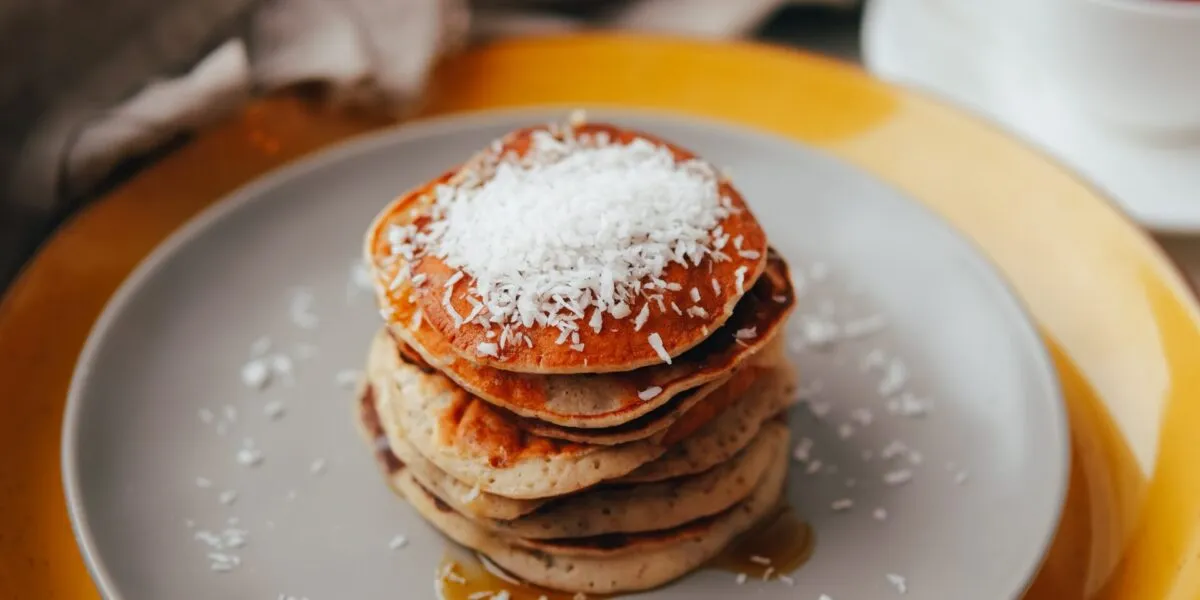 Pila di pancakes al cocco con cocco rapè in superficie