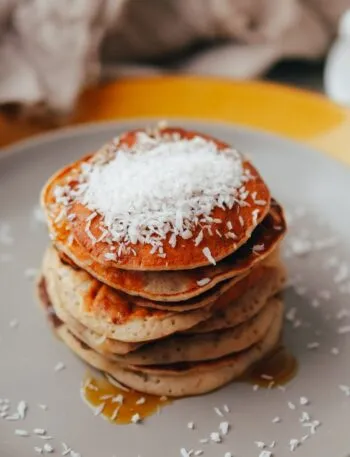 Pila di pancakes al cocco con cocco rapè in superficie