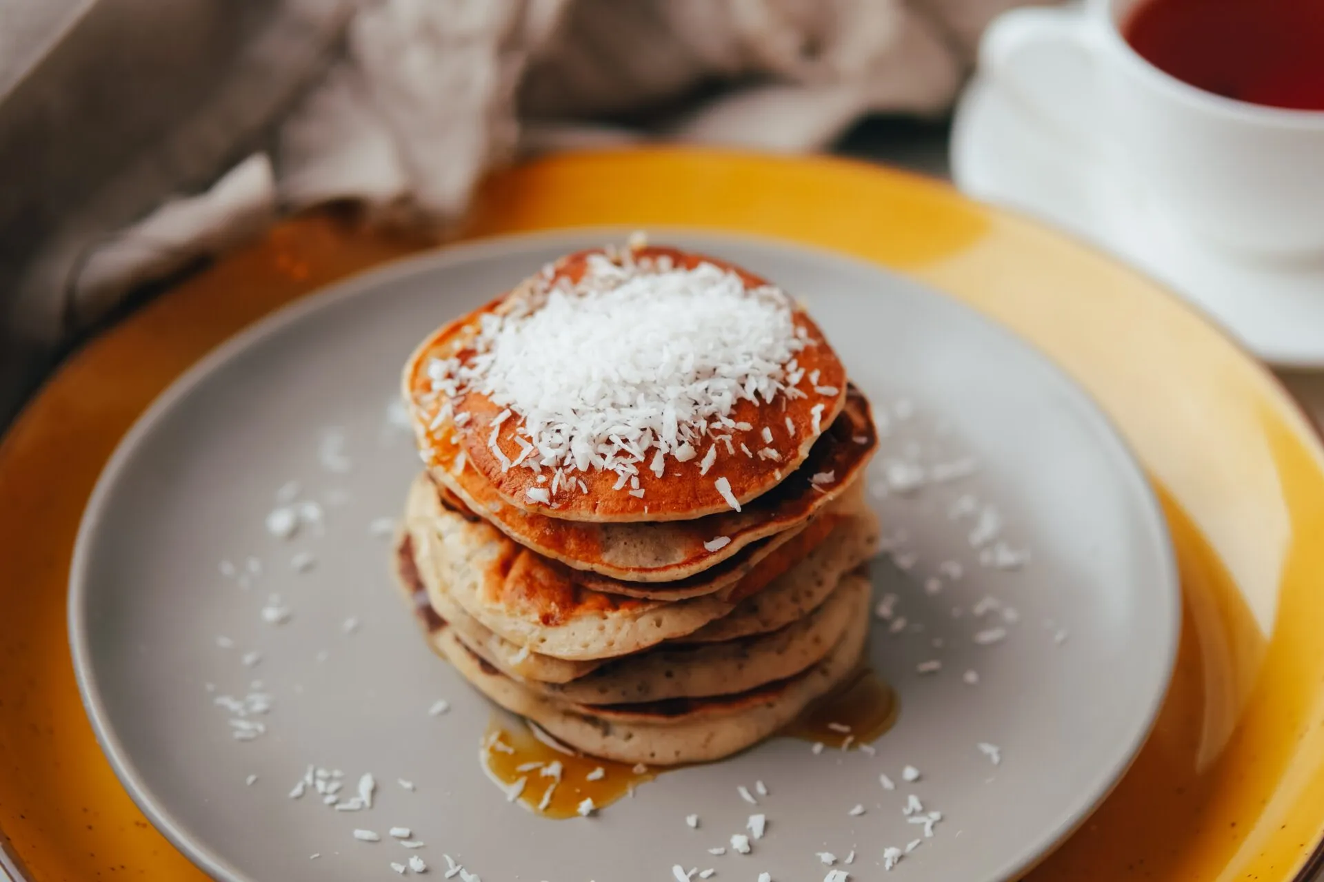 Pila di pancakes al cocco con cocco rapè in superficie