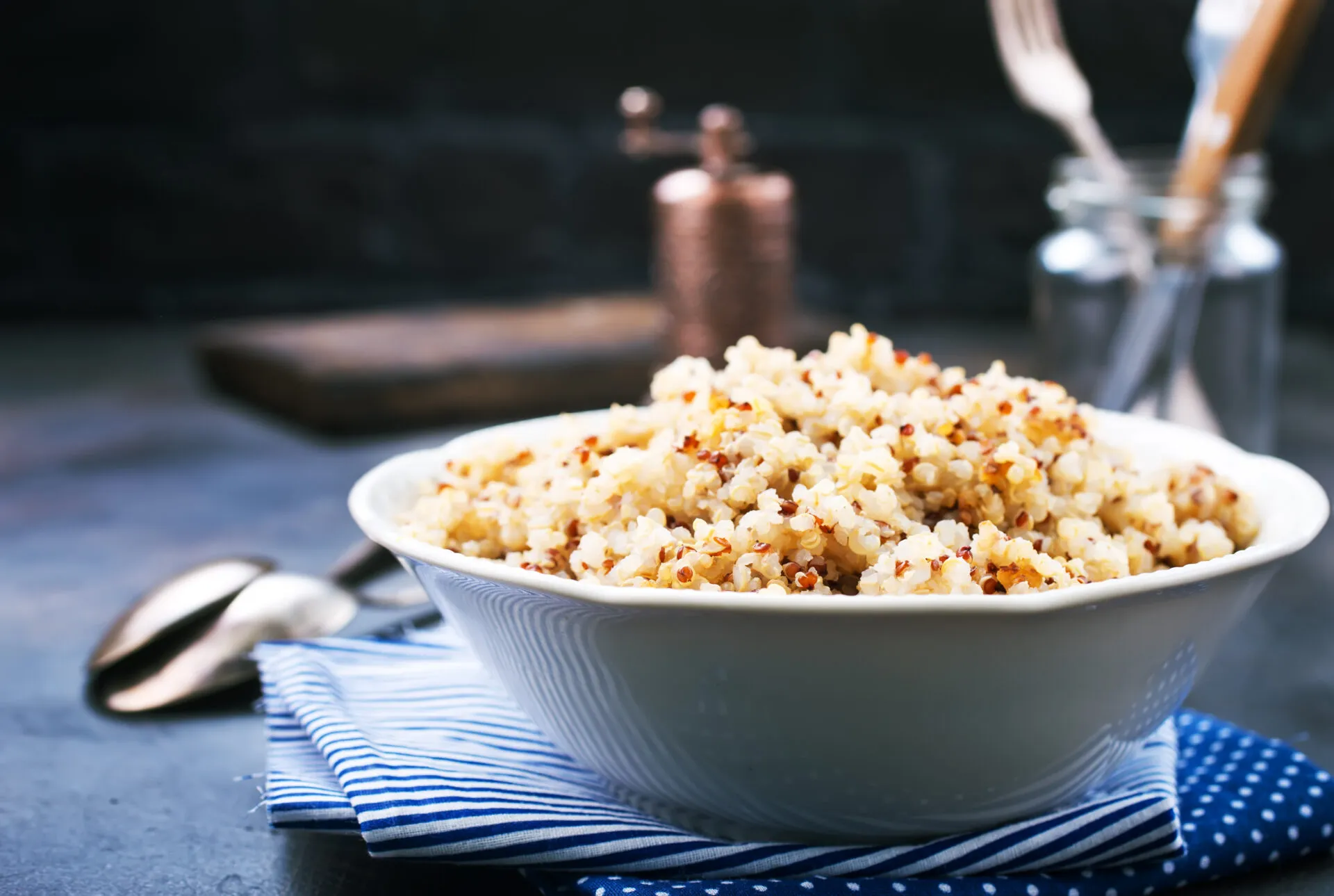 Ciotola bianca di quinoa cotta e sgranata, mista bianca e rossa, con i chicchi ben separati