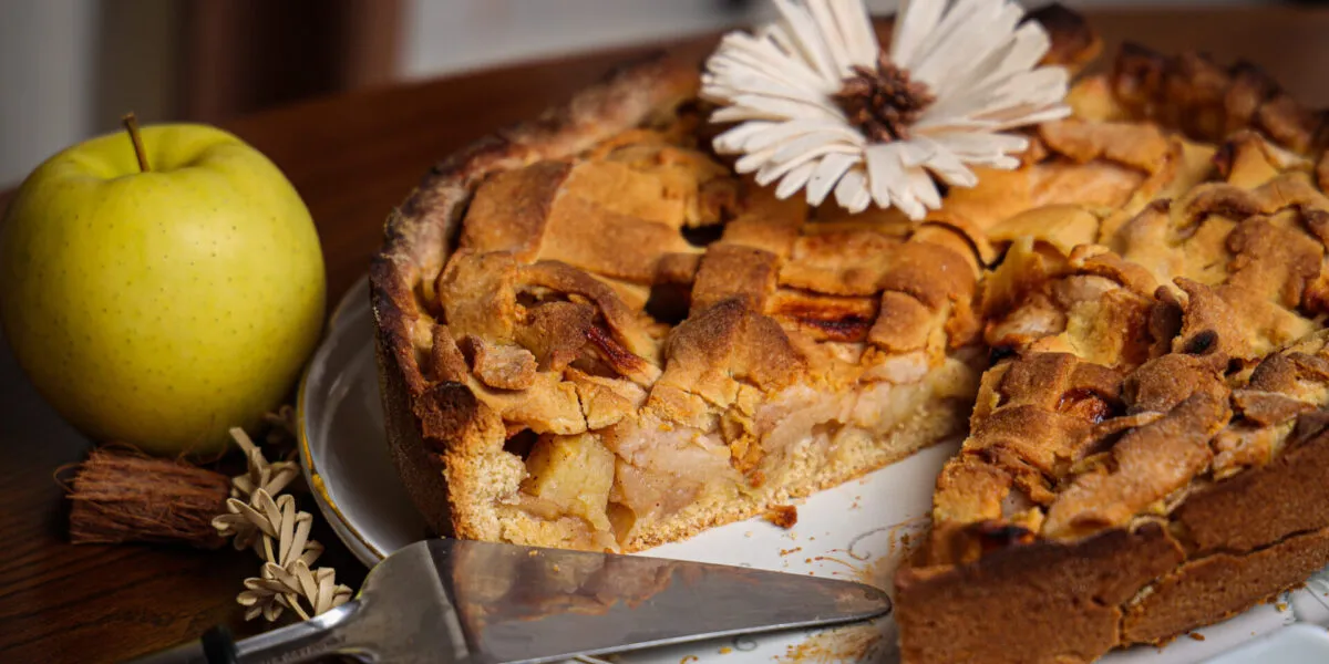 Torta di mele con copertura a strisce tagliata a fette, con lo strato di mele visibile nella sezione