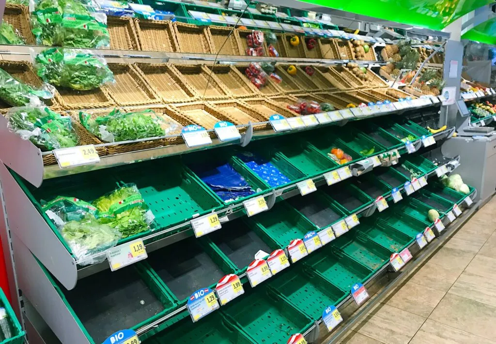 Reparto ortofrutta di un supermercato con cassette e ceste quasi vuote