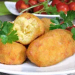 Crocchette di patate dorate con una spezzata a metà che mostra l’interno morbido