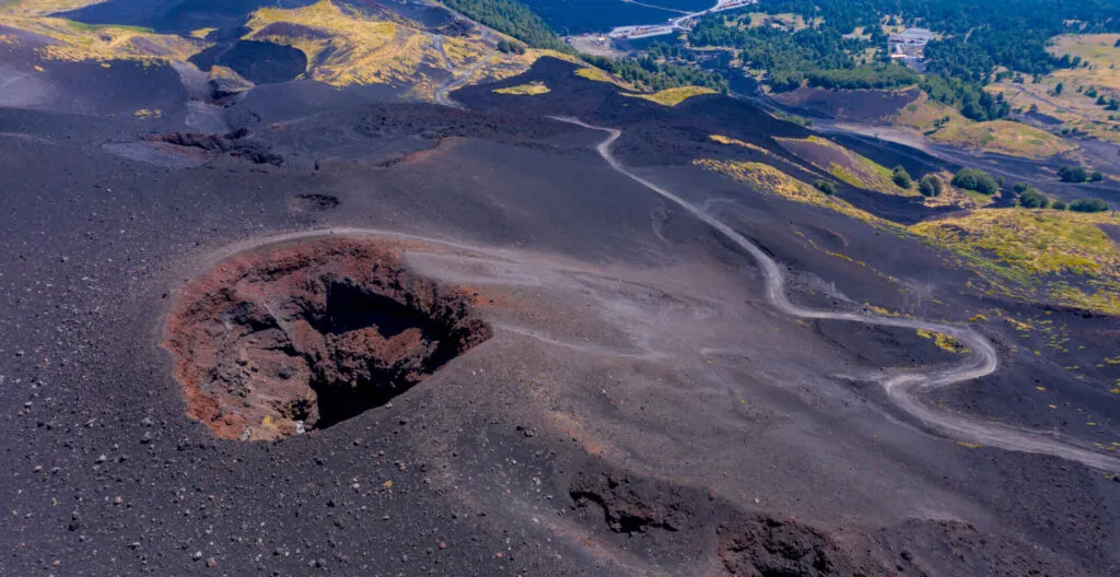 Cratere laterale dell’Etna circondato da sabbia lavica scura e colate solidificate